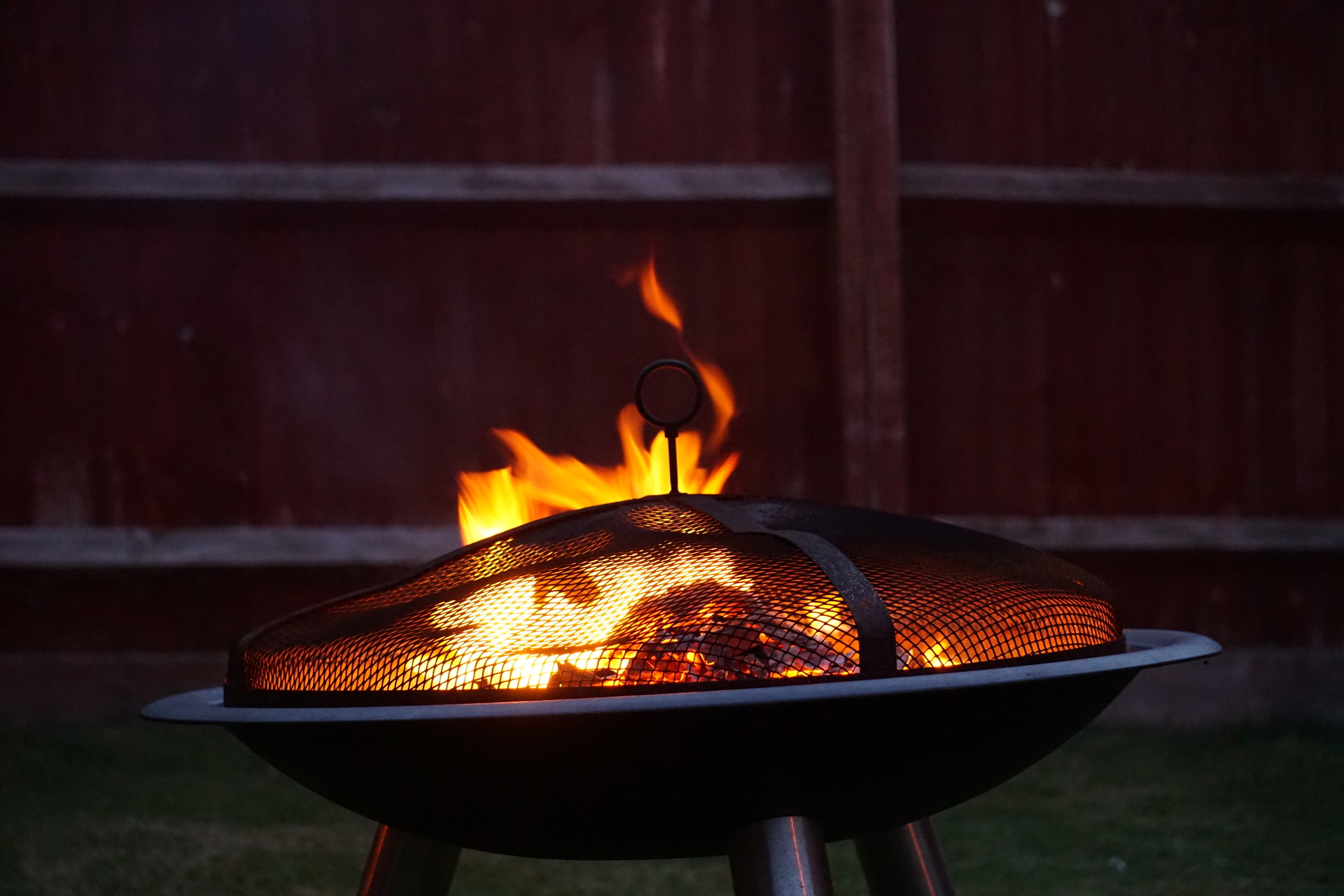 A firepit burning wood in a garden